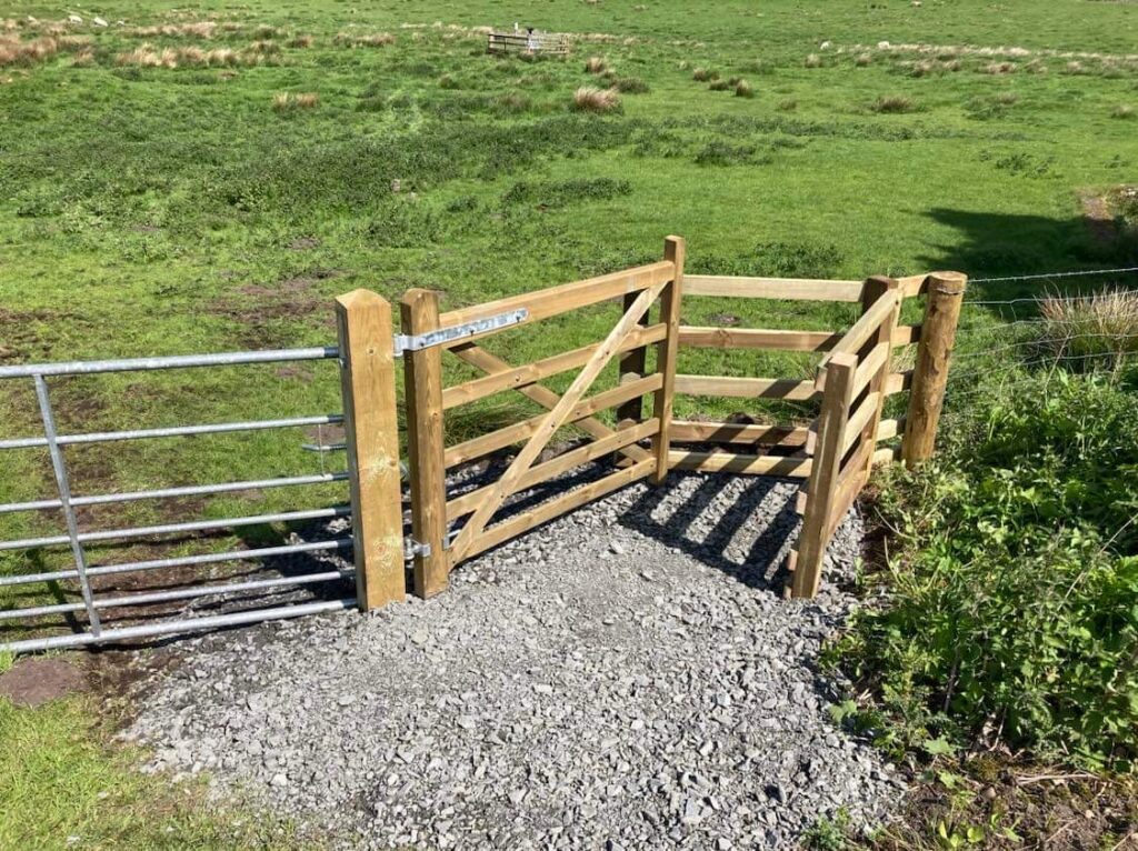 Wooden kissing gate leading to field.