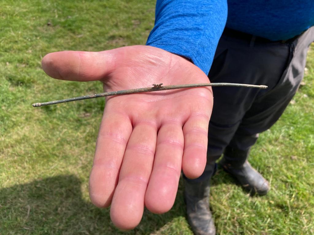 Close up of a hand holding a steelyard.