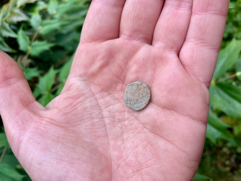 Hand holding a roman coin.