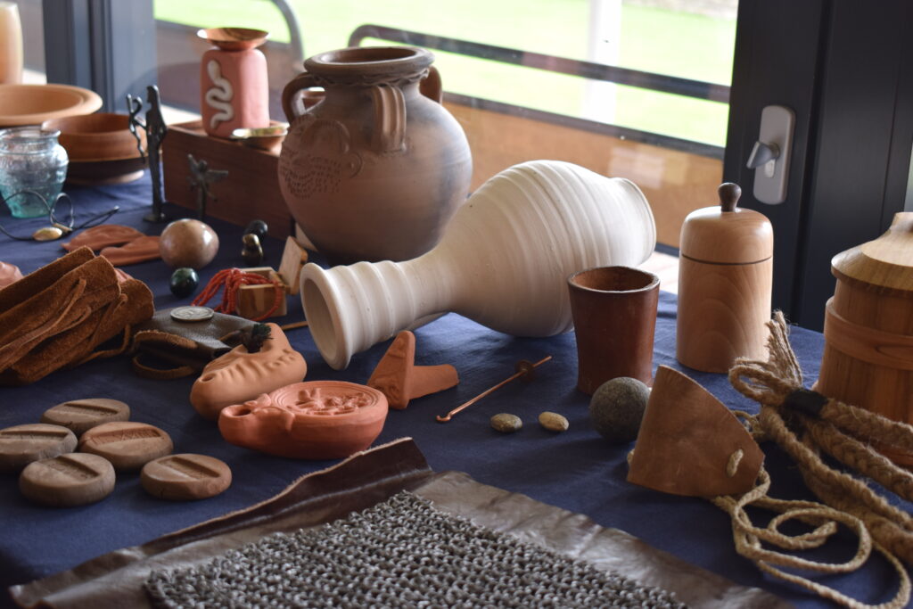 A selection of roman replica items on a blue table cloth that were used during medical practices.